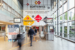 SOFTSWISS branding displayed prominently in a modern public space with people walking by.