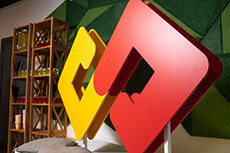 SOFTSWISS logo displayed in vibrant red and yellow colors in a modern office setting.