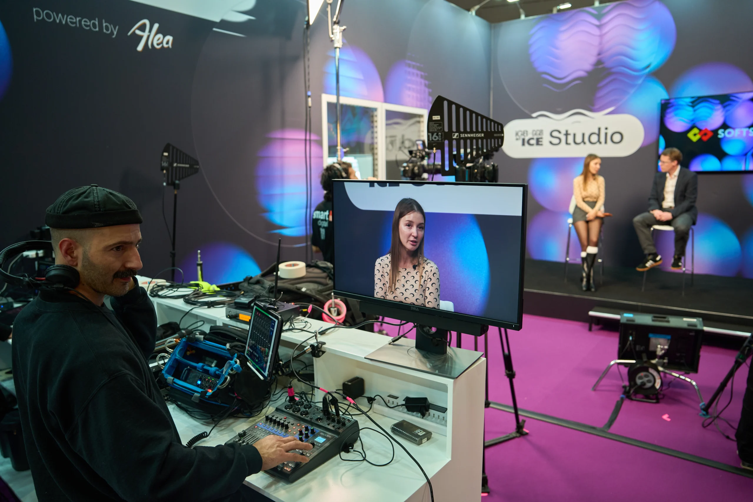 Olga Resiga and Ronnie Whelan, seat an the chairs, black and purple background and carpet