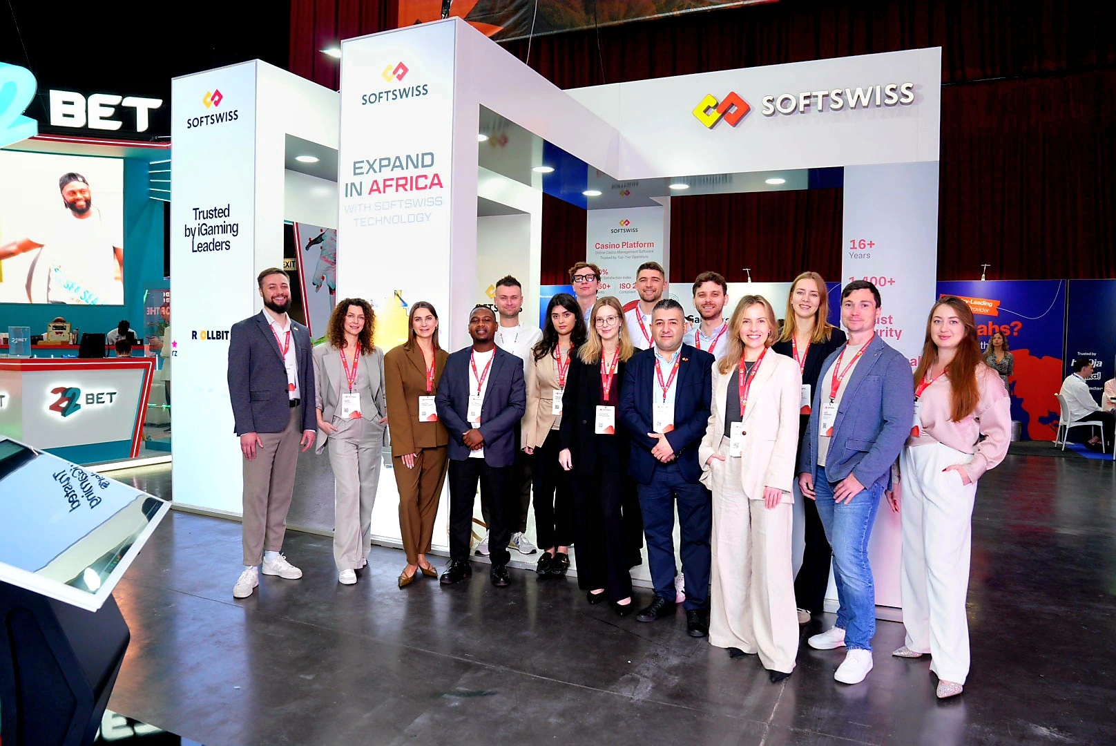 15 people, white SOFTSWISS booth in the background, SOFTSWISS logo