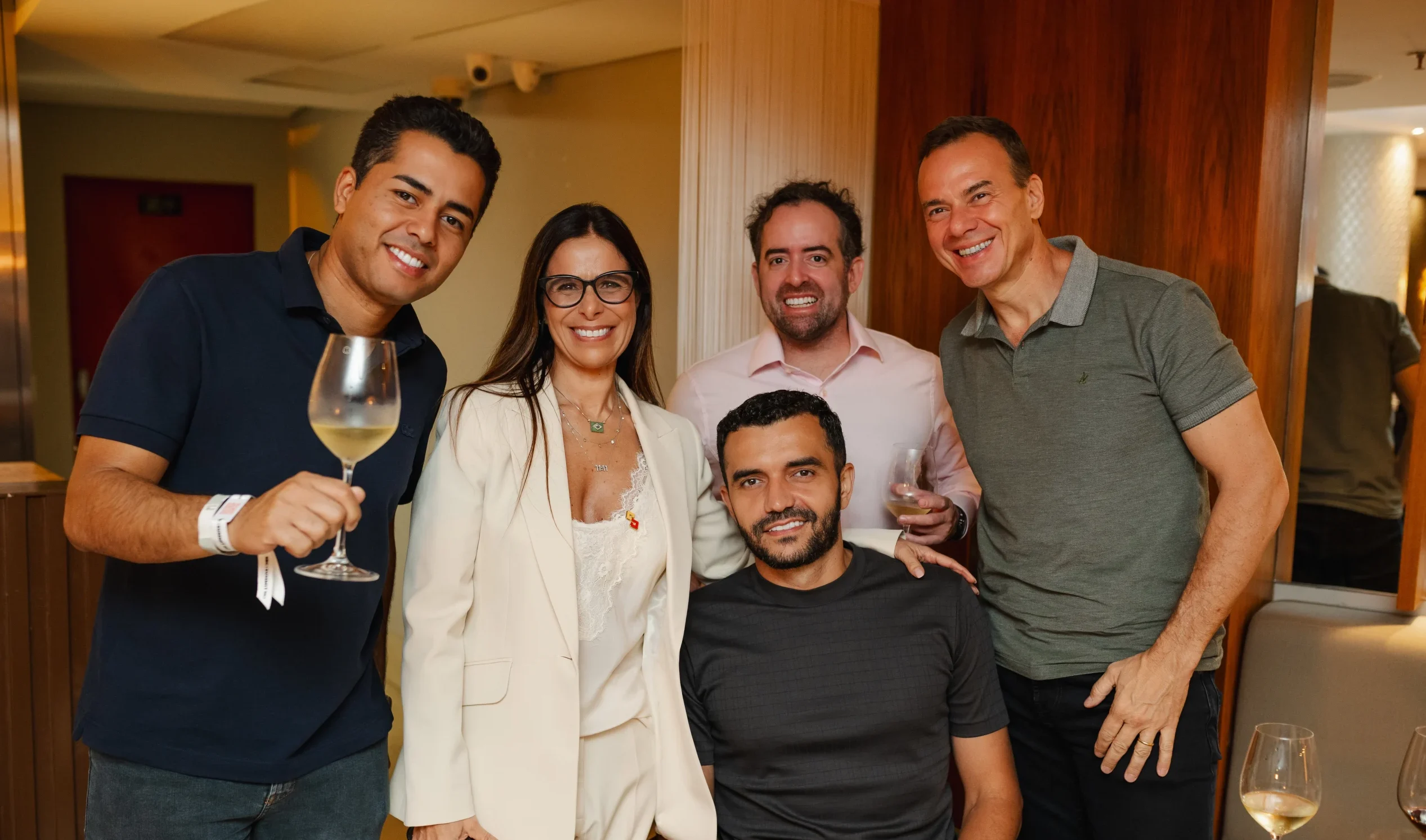 5 people smiling at the camera with glasses and drinks in their hands